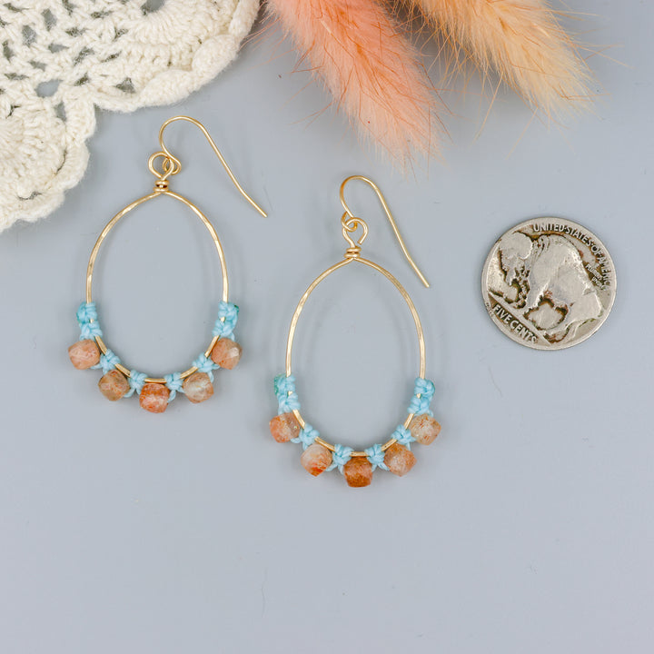 handmade sunstone and gold fill macrame earrings with a nickel for size comparison