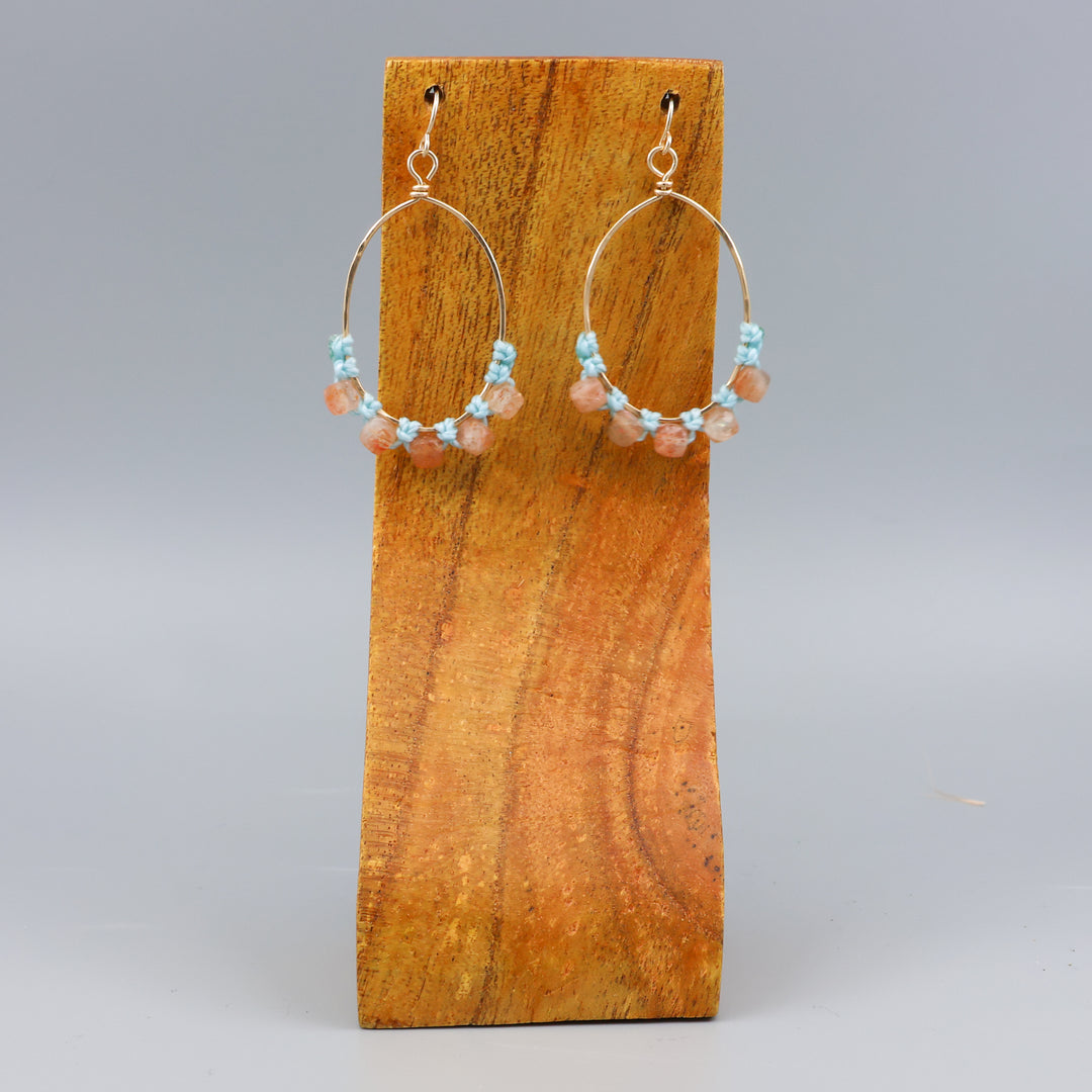 handmade sunstone and gold fill macrame earrings on a wood display