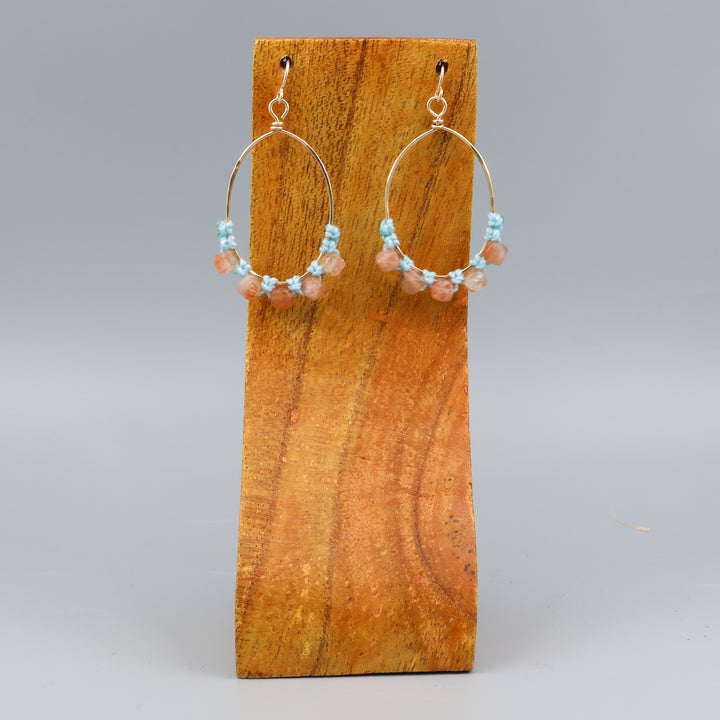 handmade sunstone and gold fill macrame earrings on a wood display