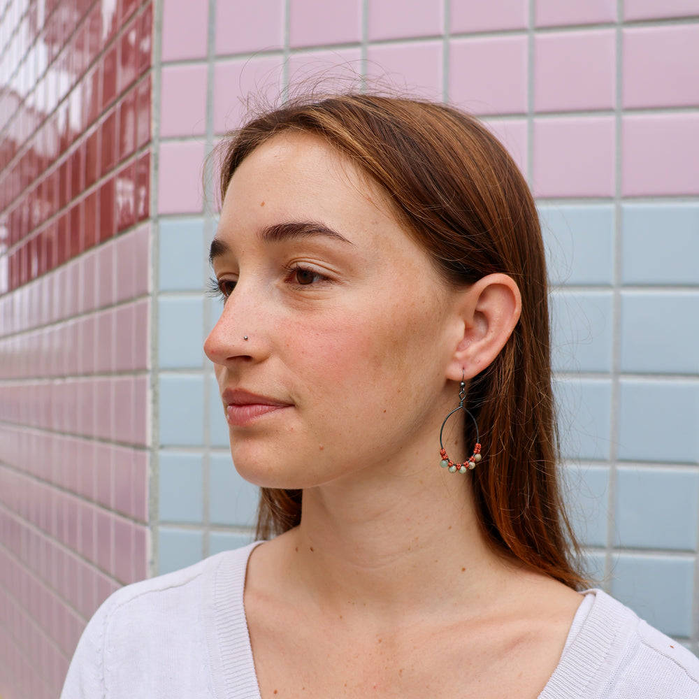oxidized sterling silver macrame hoop earrings with aqua terra jasper beads worn on a model