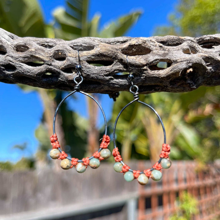 oxidized sterling silver hoop earrings with aqua terra jasper beads hanging from a cholla branch outdoors
