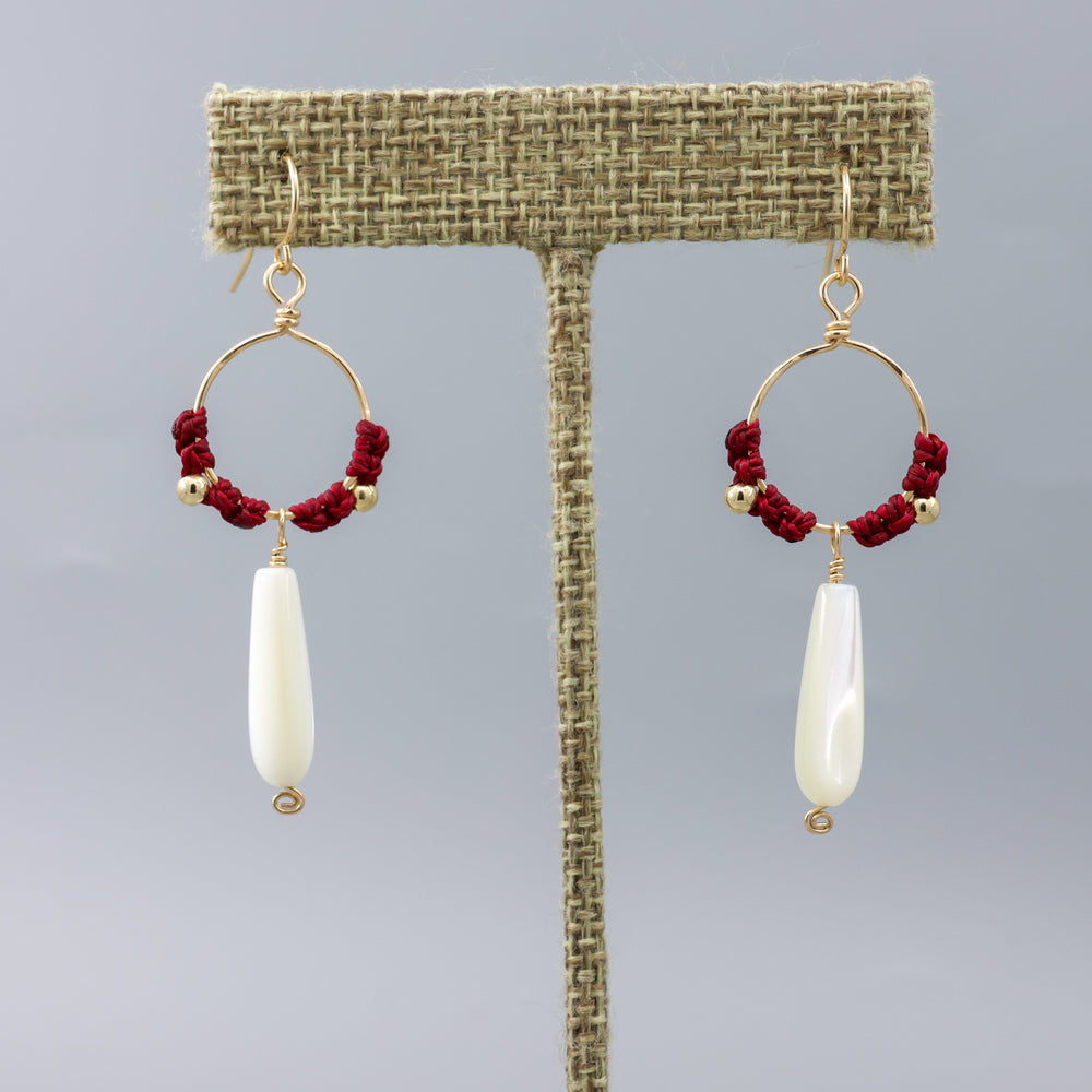 handmade gold hoops with mother of pearl beads and red macrame on a linen hanger