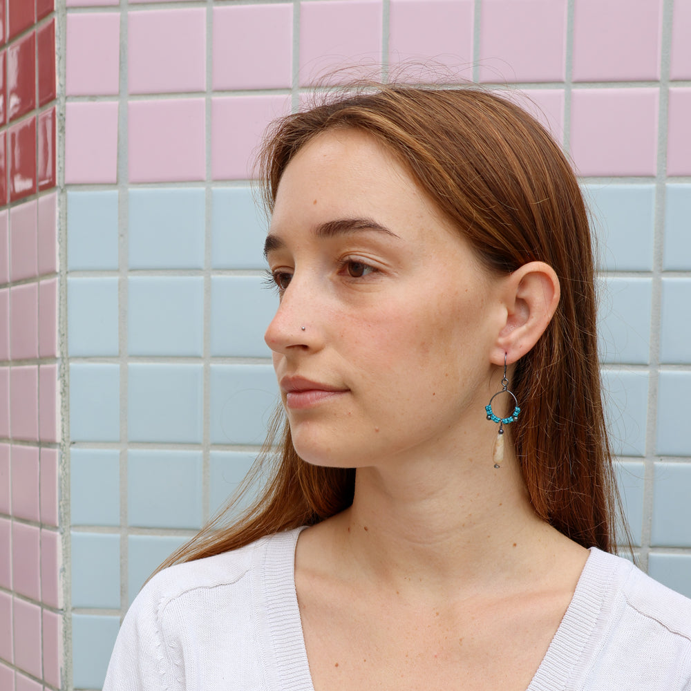 macrame hoop earrings with botswana teardrop shaped bead worn on a model