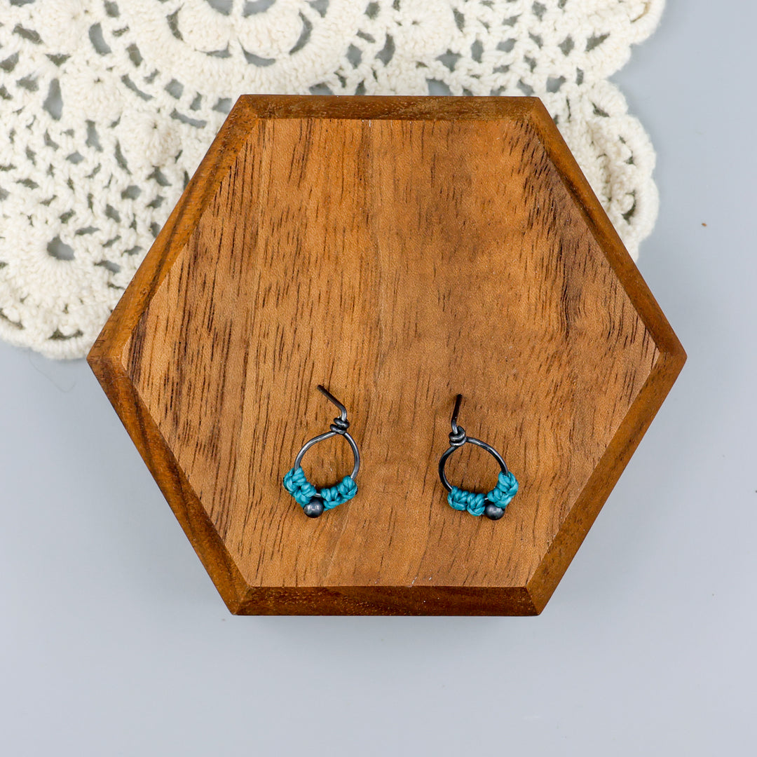 small, oxidized sterling silver macrame stud earrings in turquoise overhead view