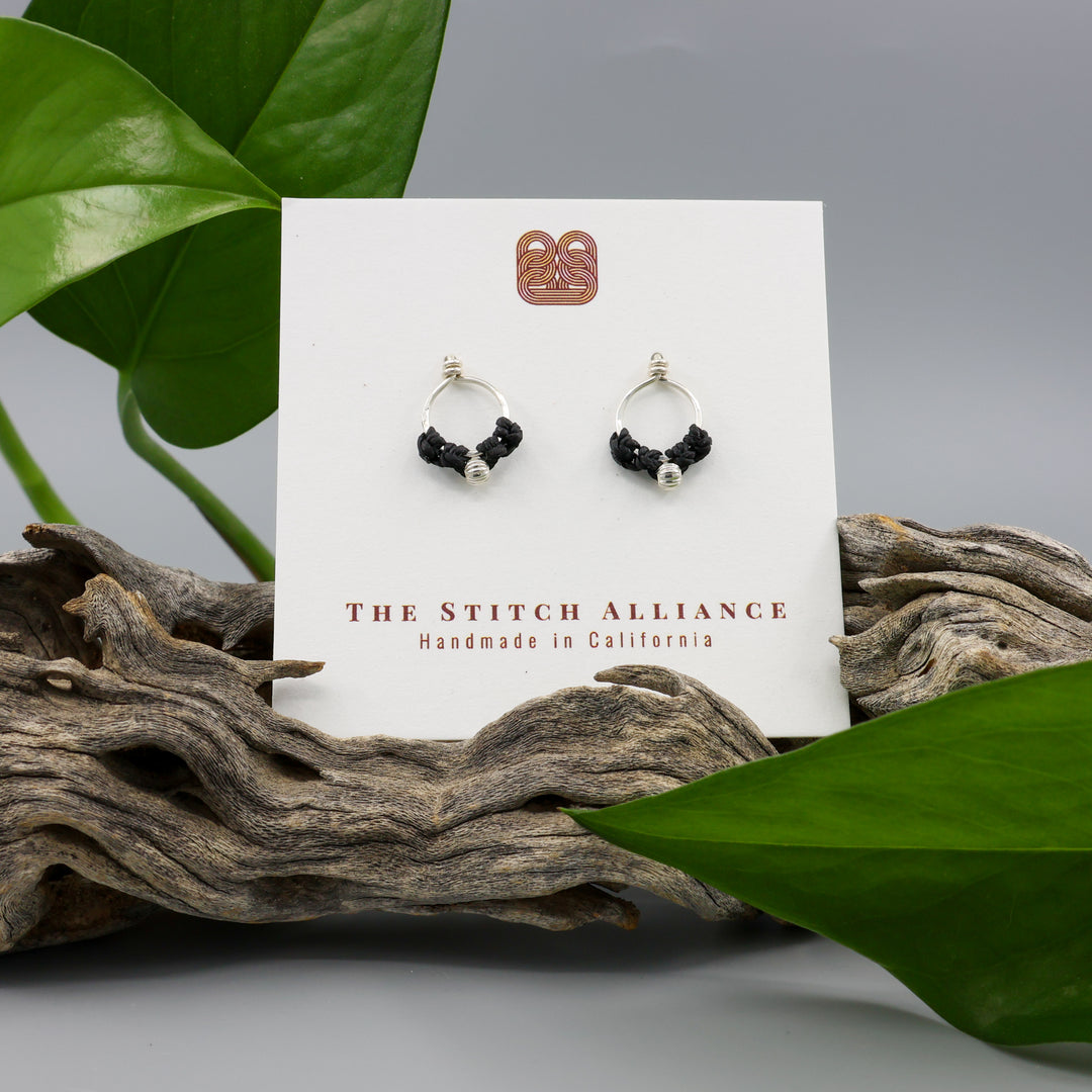 handmade sterling silver macrame stud earrings on. white card and gray background