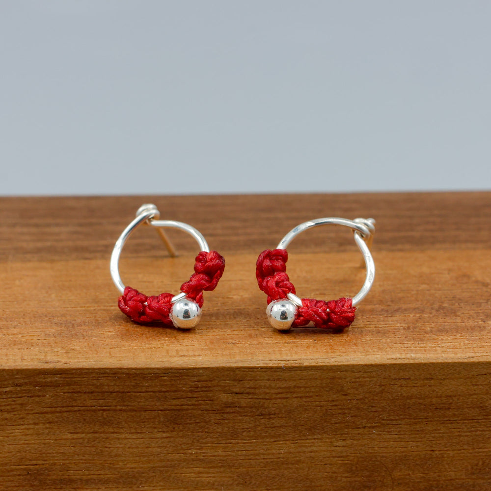 handmade sterling silver red macrame earrings on a wood base