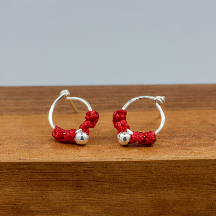 handmade sterling silver red macrame earrings on a wood base