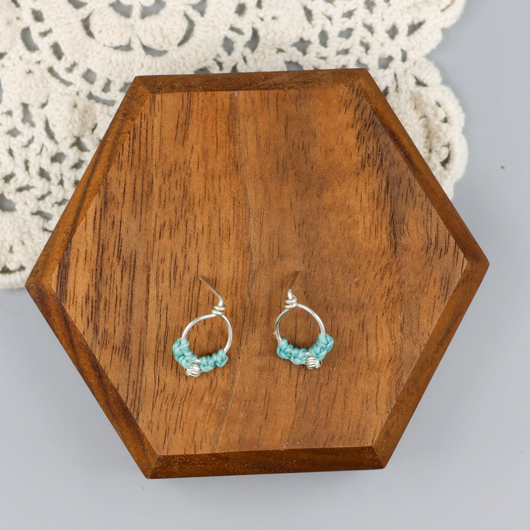 sterling silver macrame earrings aqua blue on a wood block
