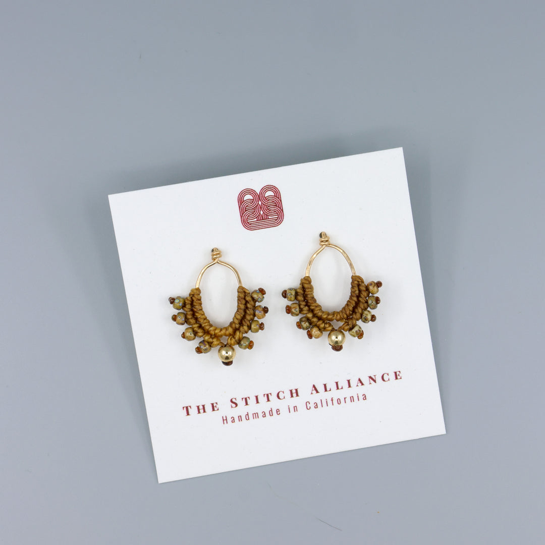 handmade gold macrame earrings on a white card
