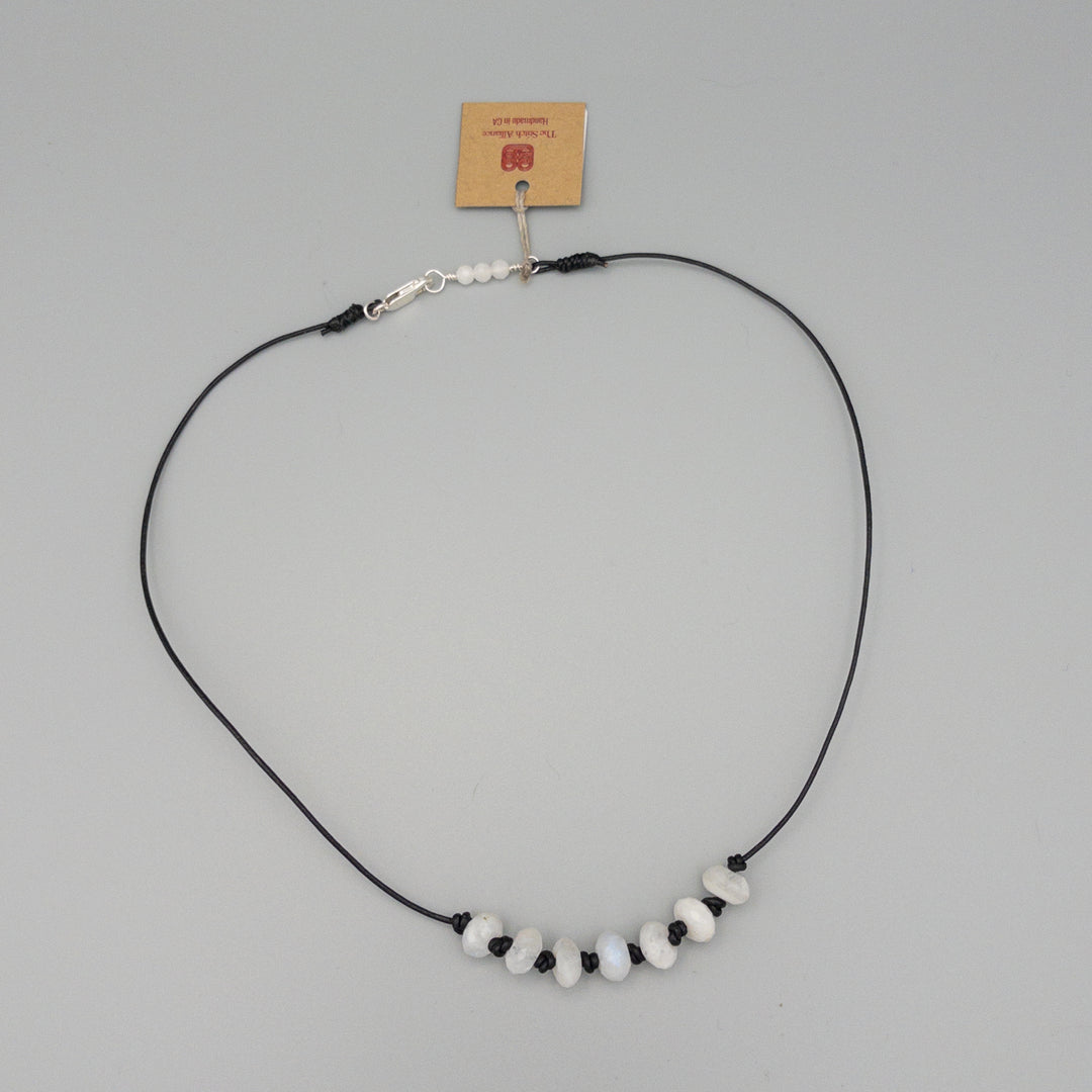 hand knotted rainbow moonstone beaded necklace on black leather with sterling silver clasp on gray background