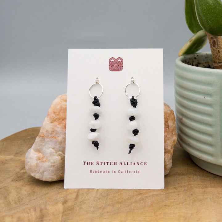 Rainbow moonstone leather knotted earrings with sterling silver circle posts on white card