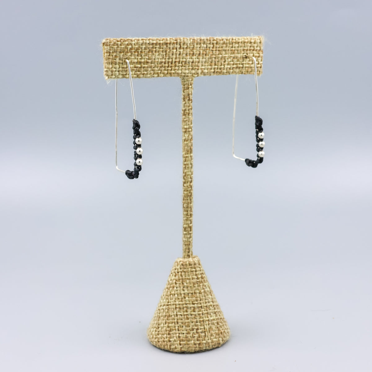 handmade sterling silver rectangle hoops with macrame detail on a linen hanger