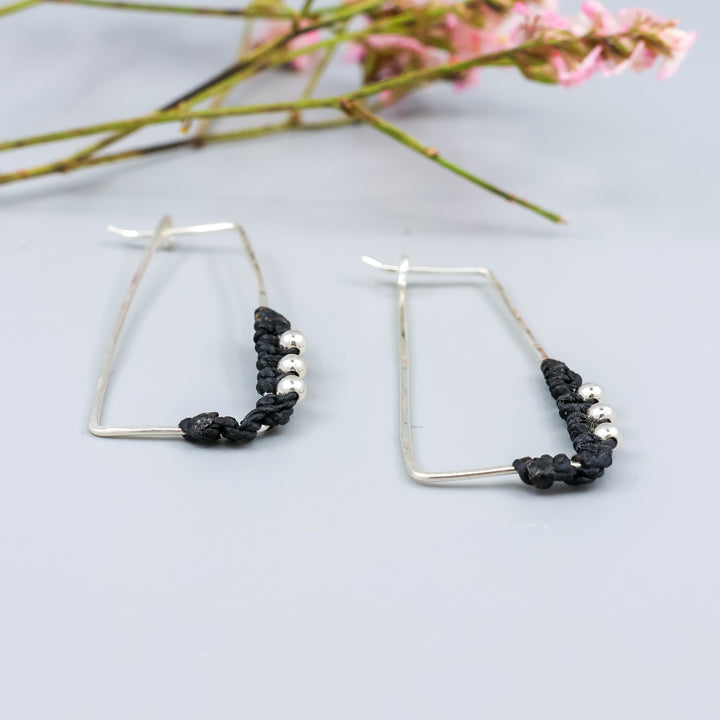 detail view of handmade sterling silver rectangle hoops with macrame detail