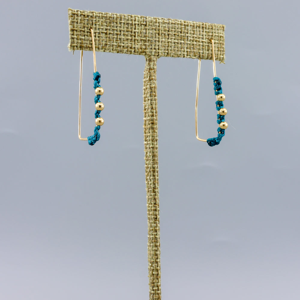 handmade gold hoop earrings with teal blue macrame details 
