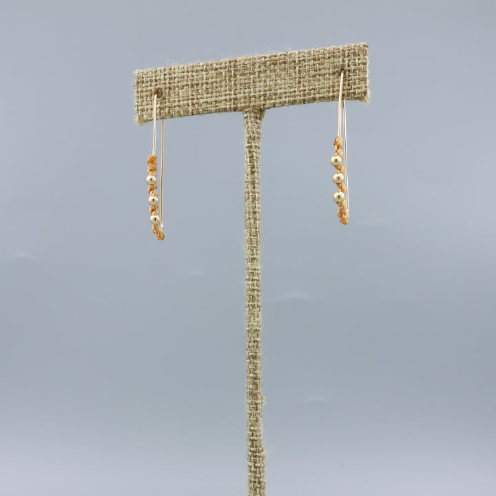 gold filled rectangle macrame hoop earrings on a linen hanger