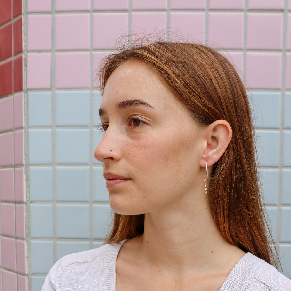 gold macrame hoop earrings worn on a model