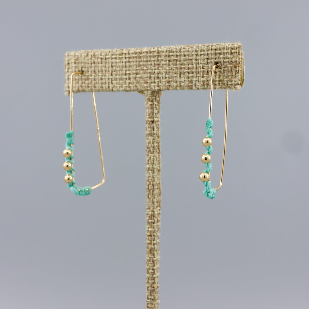gold fill rectangle hoop earrings with seafoam macrame and gold beads on a linen hanger