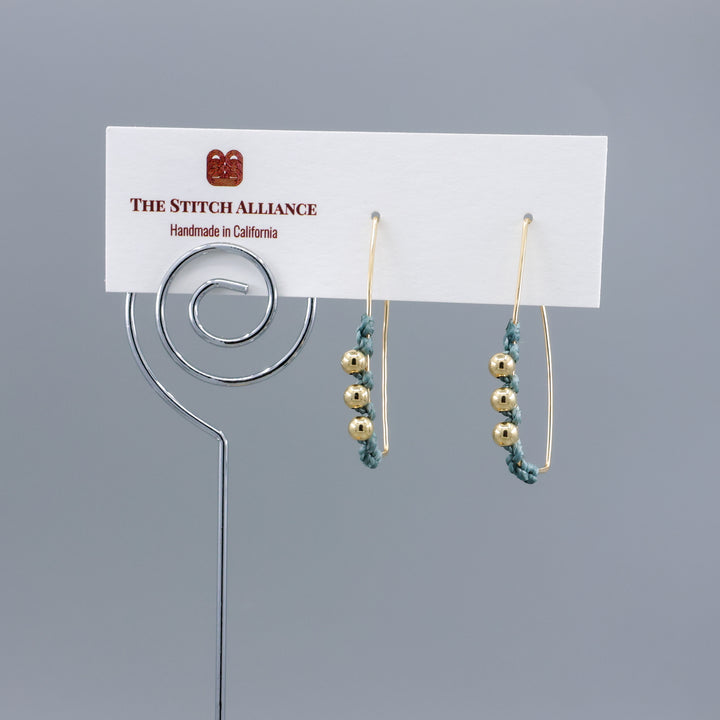 gold fill rectangle hoop earrings with macrame details on a white card