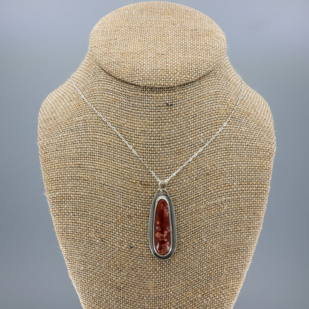 handmade red jasper sterling silver pendant on sterling silver chain on a burlap display