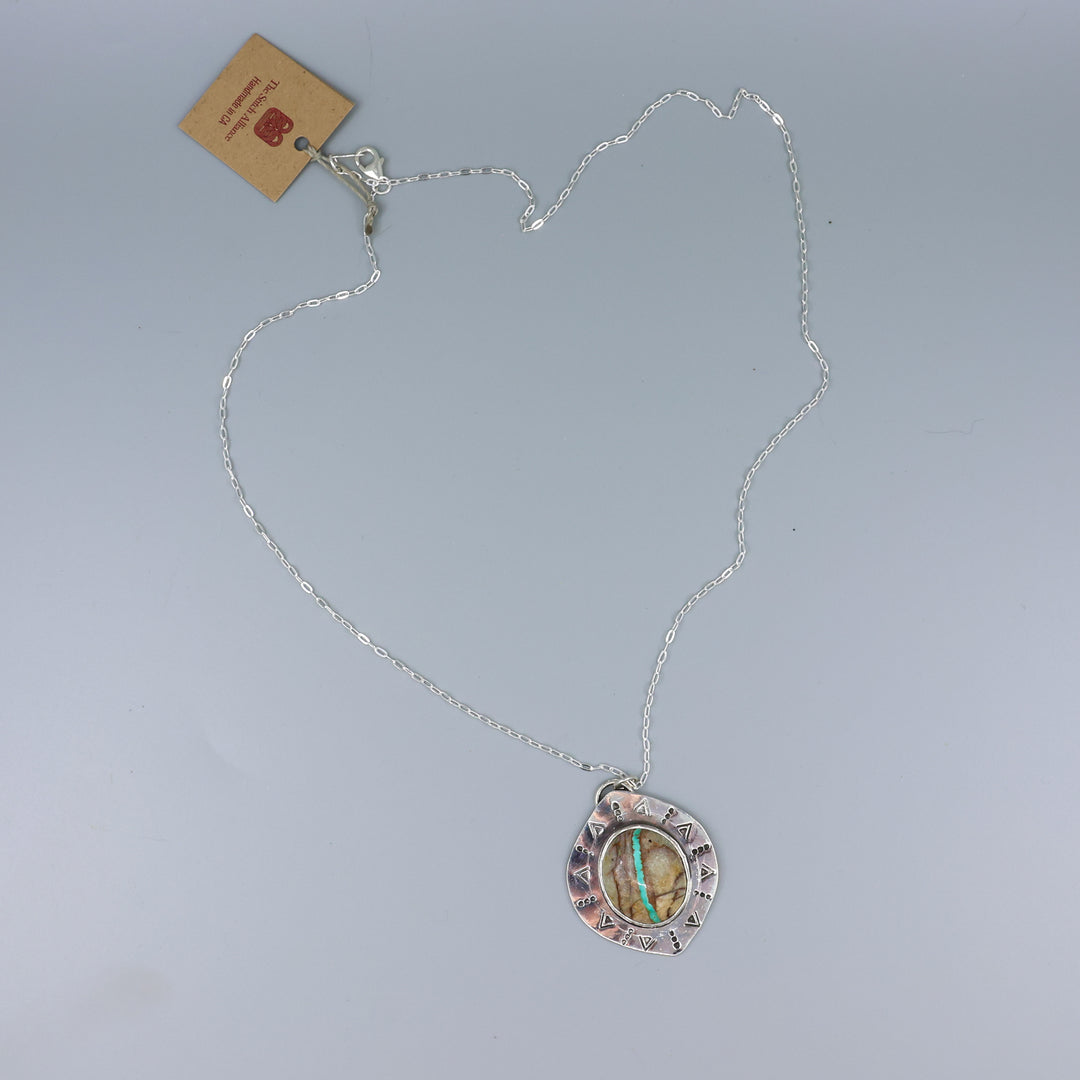one of a kind ribbon turquoise sterling silver necklace on a gray background