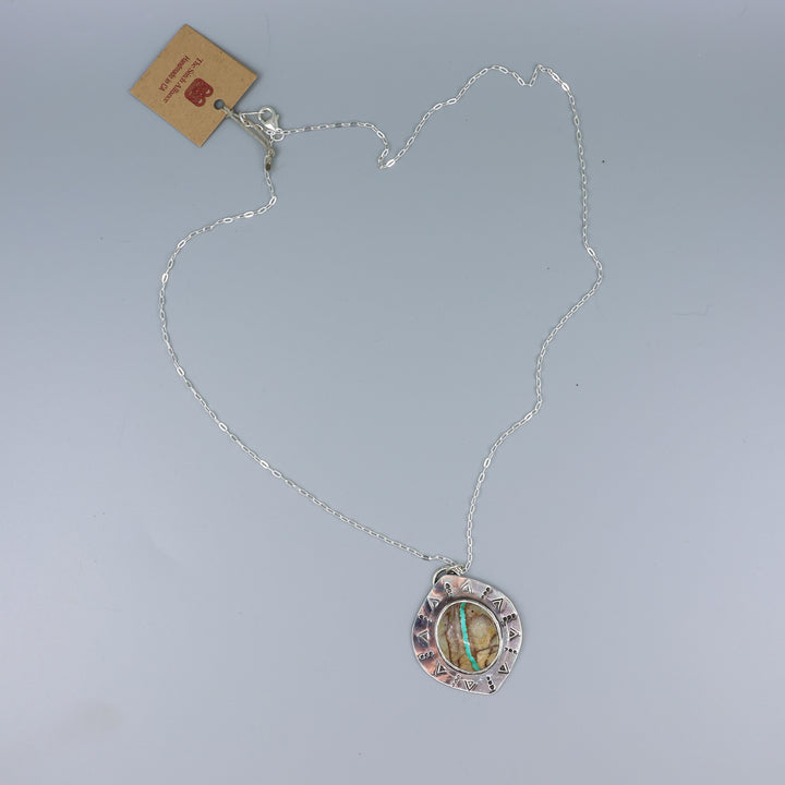 one of a kind ribbon turquoise sterling silver necklace on a gray background