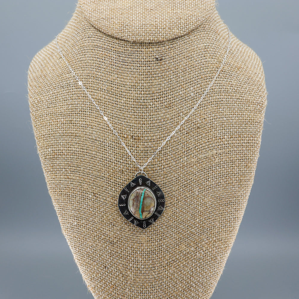 one of a kind ribbon turquoise sterling silver necklace on a mannequin
