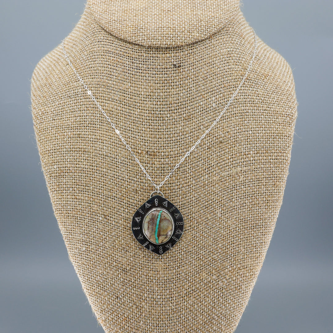one of a kind ribbon turquoise sterling silver necklace on a mannequin