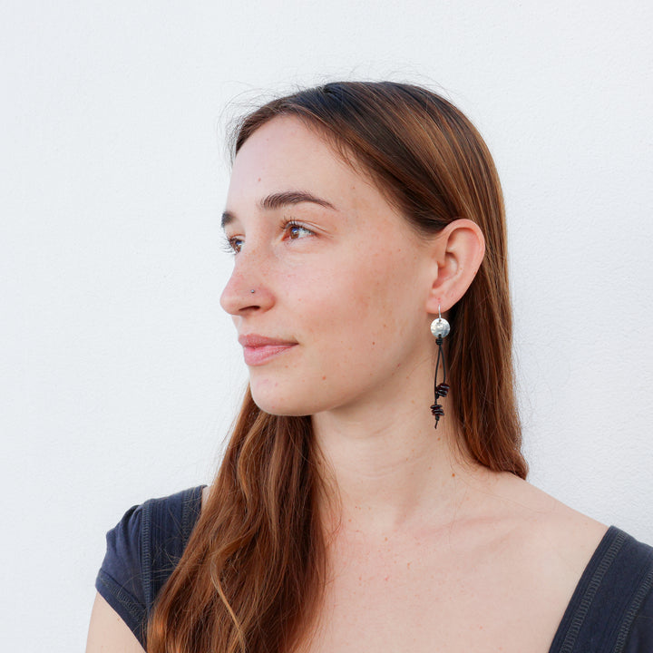 handmade earrings featuring heart stamped discs with garnet beads hanging from leather cords