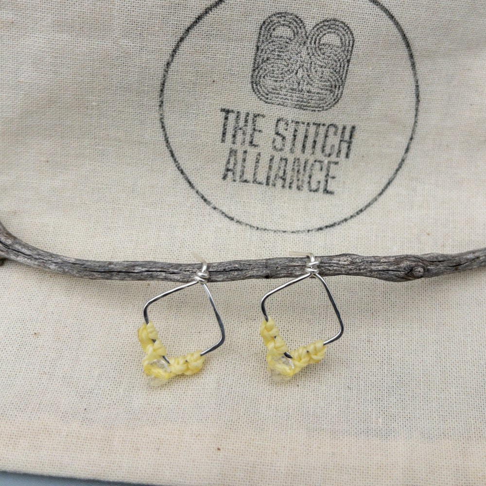 Sagittarius citrine earrings in sterling silver shown on a muslin bag