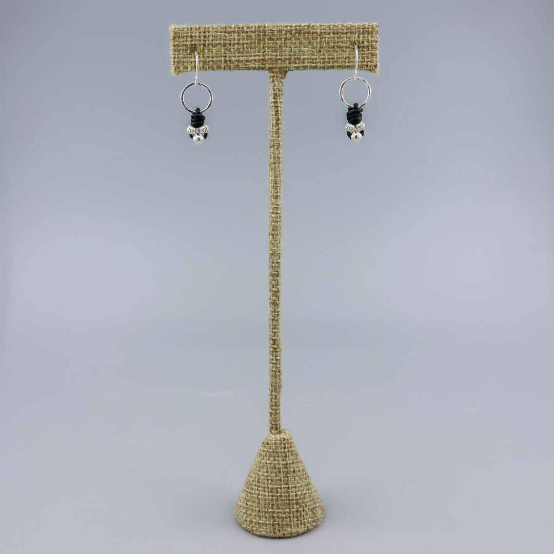 handmade sterling silver and leather knotted earrings on a linen hanger