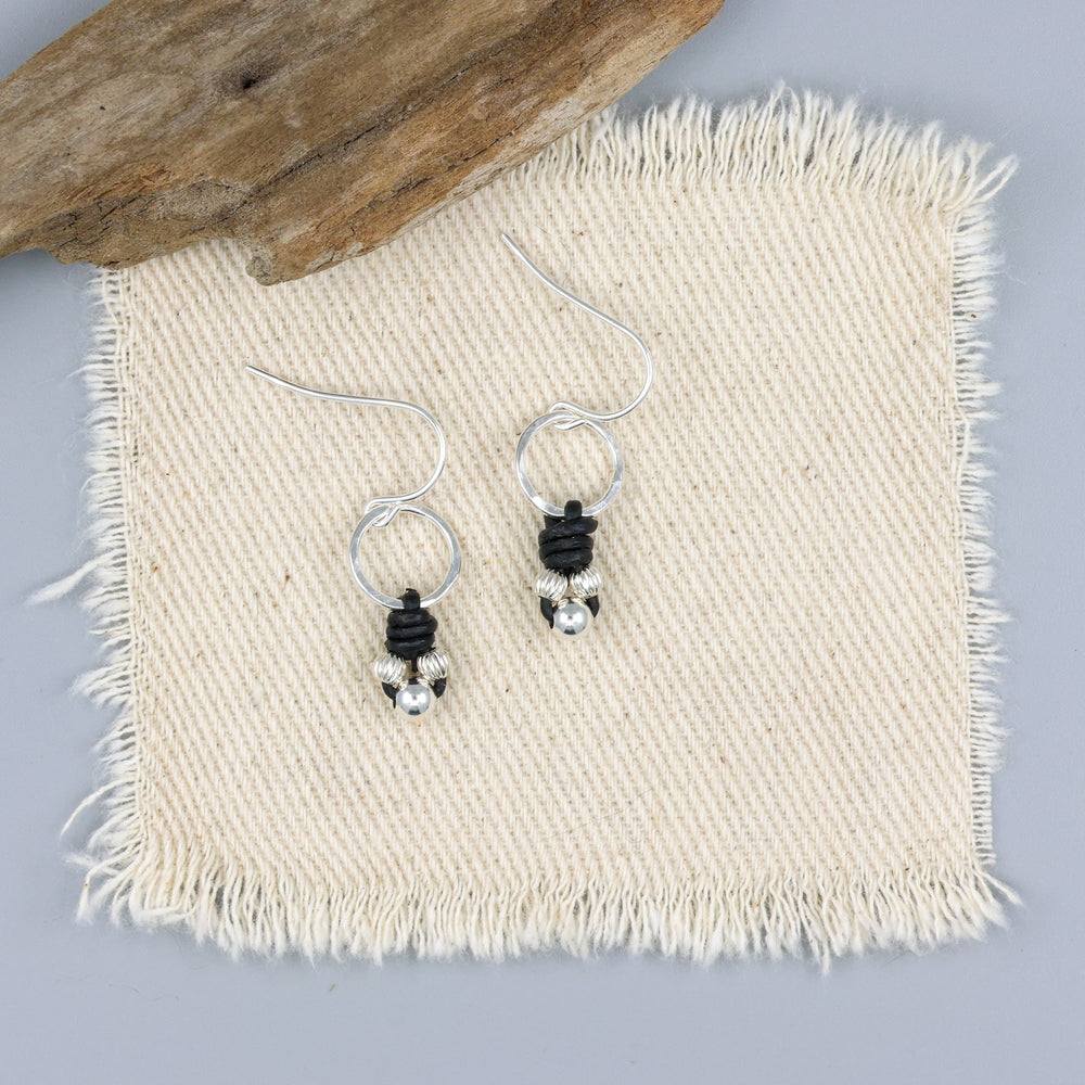 handmade sterling silver and leather knotted earrings on an off white background