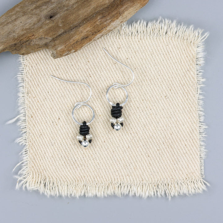 handmade sterling silver and leather knotted earrings on an off white background