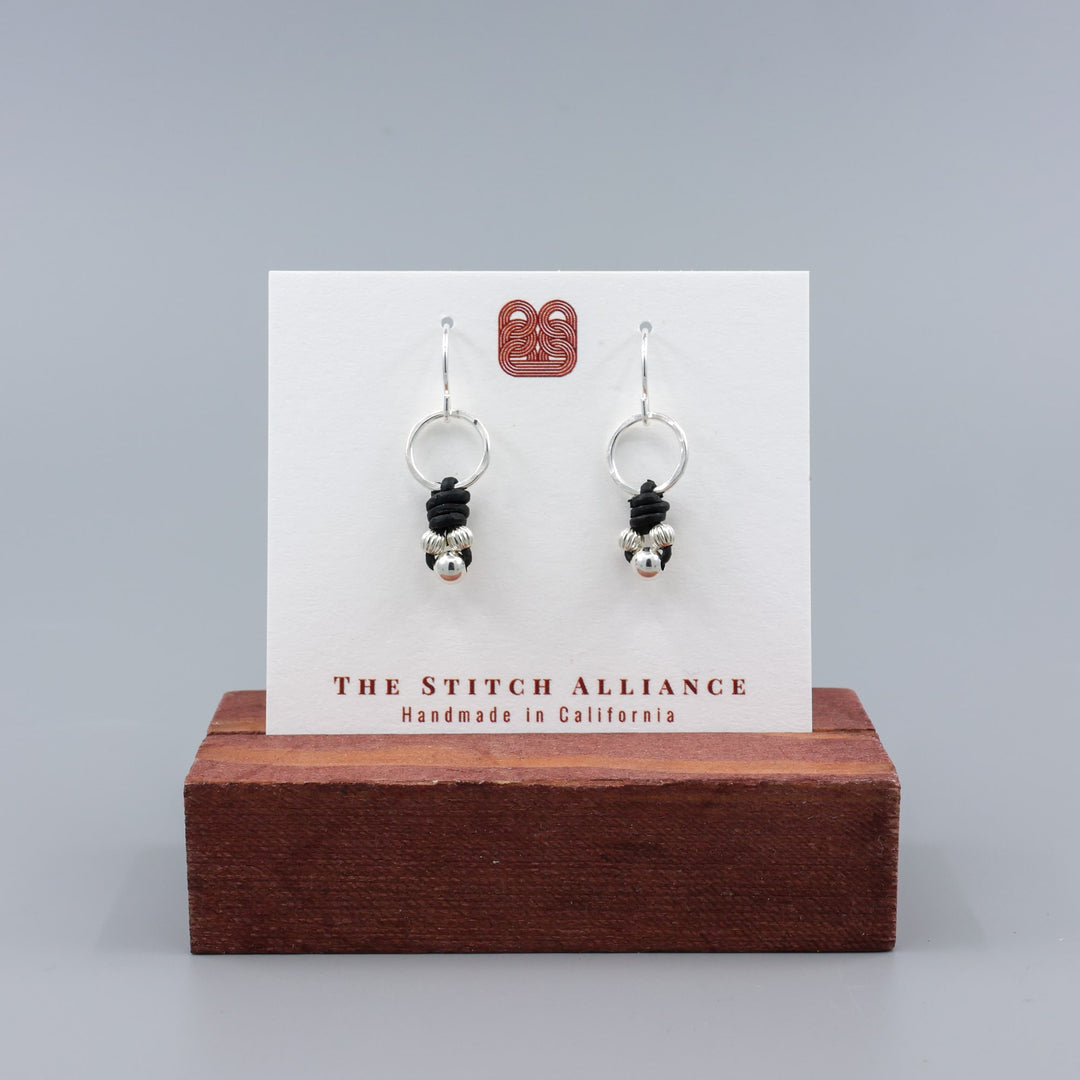 handmade sterling silver and leather knotted earrings on a white card