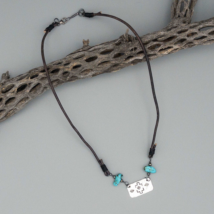 Boho western stamped silver turquoise and leather necklace on gray background