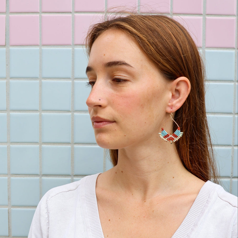 gold square macrame hoop earrings worn on a model