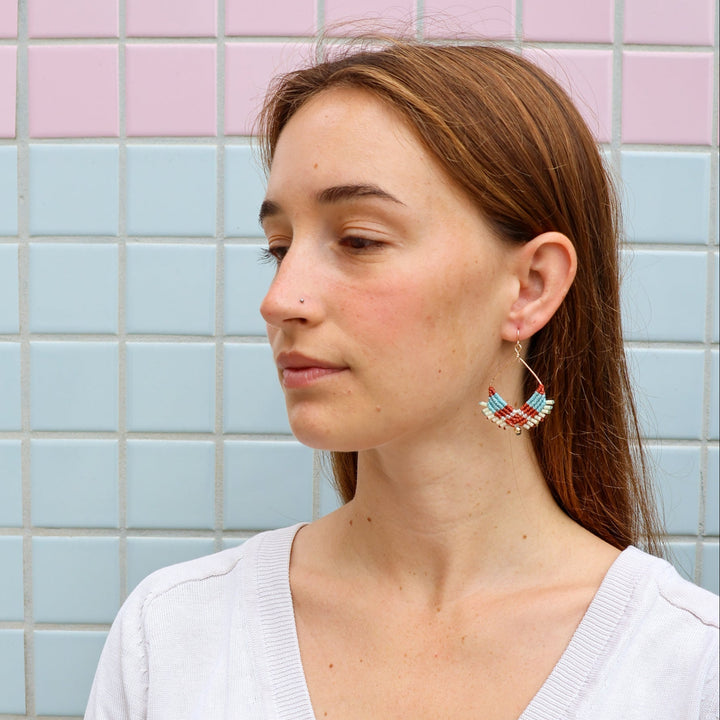 gold square macrame hoop earrings worn on a model