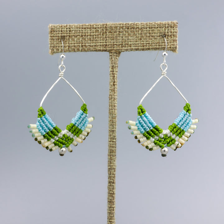handmade sterling silver macrame hoop earrings in light blue, green, and cream on a linen display hanger