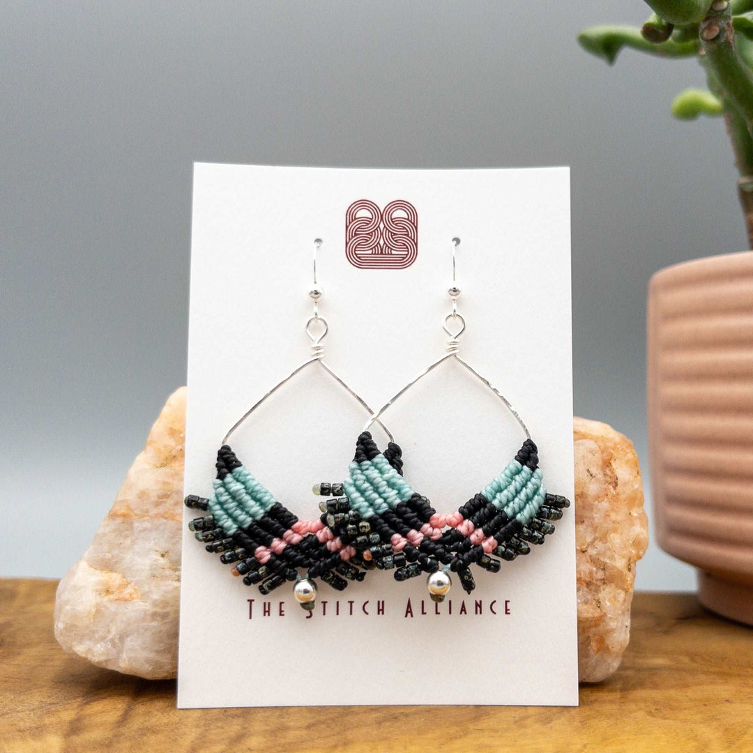 handmade macrame square hoop earrings in black, aqua, and pink with sterling silver wire on a white card