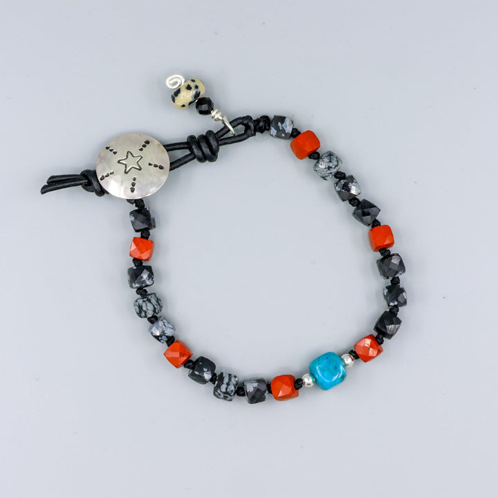 handmade turquoise, jasper, and larvikite beaded bracelet with a star-stamped sterling silver button closure  on a gray background