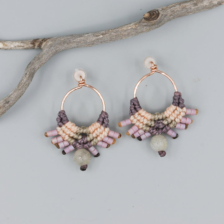 handmade macrame earrings in rose gold, peach and dusty purple with a labradorite bead on a gray background