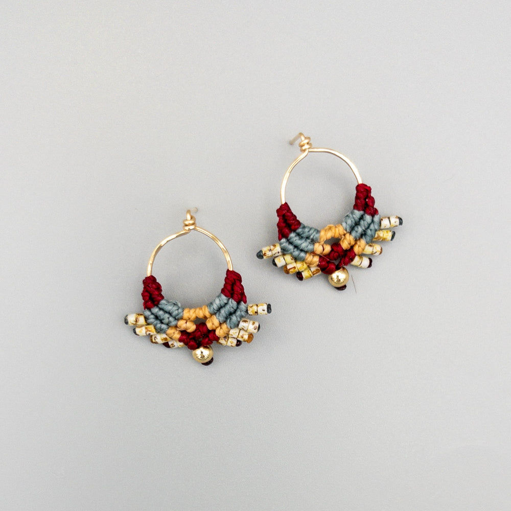 deep red, dusty blue, and tan macrame earrings in 14k gold fill on a gray background