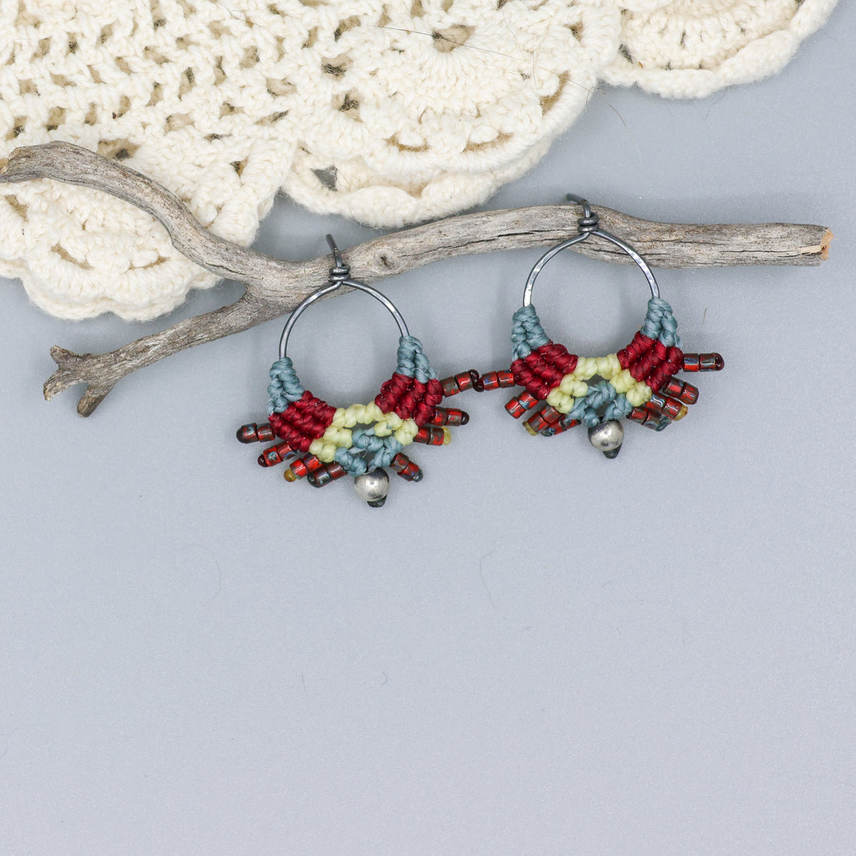 handmade macrame stud earrings in blue, deep red, and pale yellow with oxidized sterling silver metal