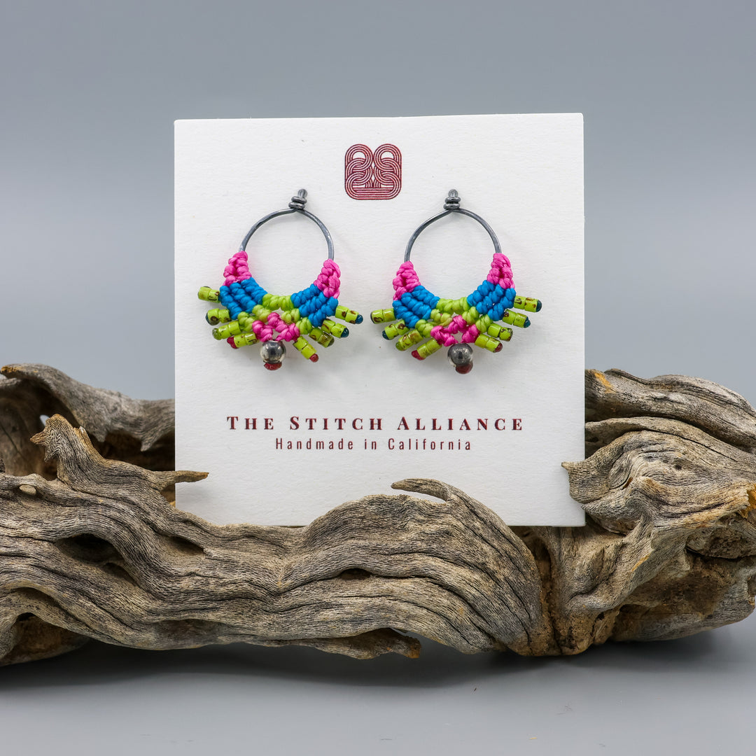 handmade macrame earrings in sterling silver and bright green, pink, and blue on a white card