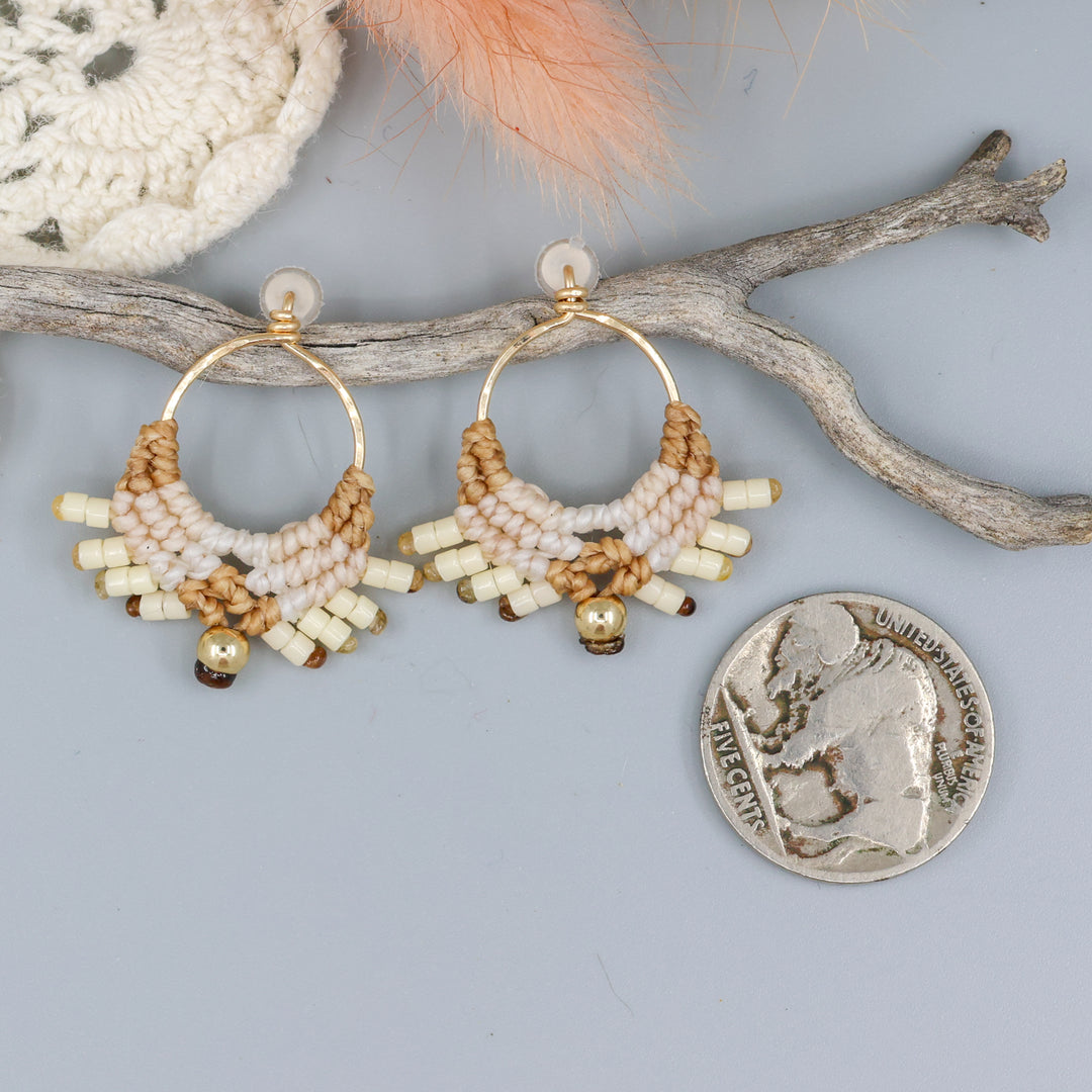 handmade macrame earrings with gold fill wire in tan colors with a nickel for size comparison