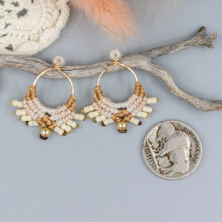 handmade macrame earrings with gold fill wire in tan colors with a nickel for size comparison