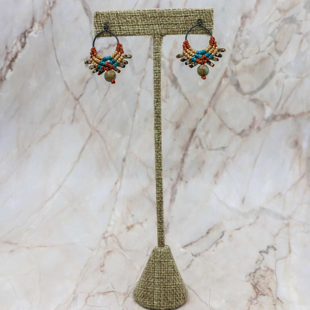 handmade macrame earrings shown on a linen hanger