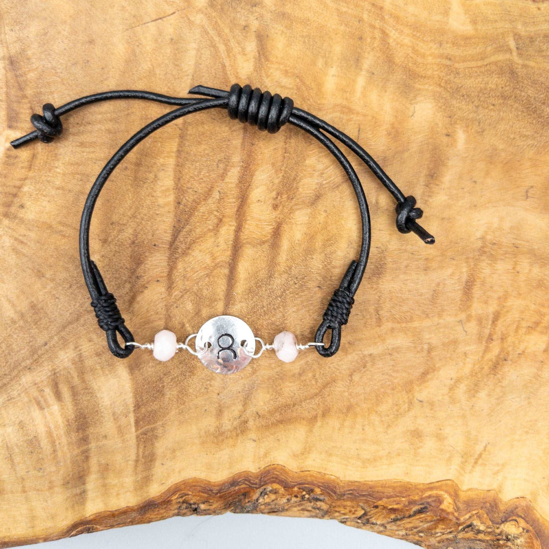 Taurus bracelet hand stamped sterling silver with rose quartz beads on wood background