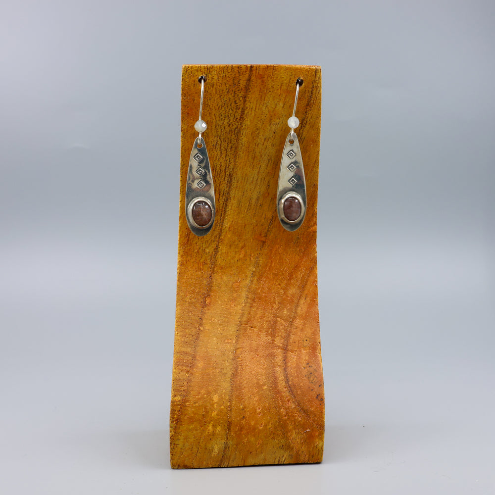 handmade silver sunstone one of a kind earrings on wood background