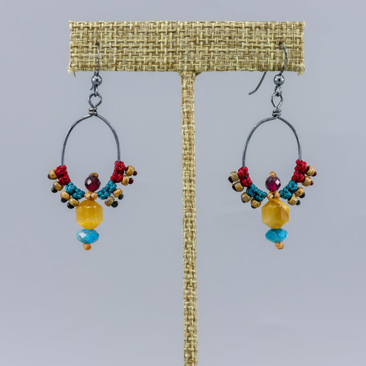 handmade oxidized sterling silver macrame hoop earrings with golden tiger's eye, apatite, and garnet beads on a gray background