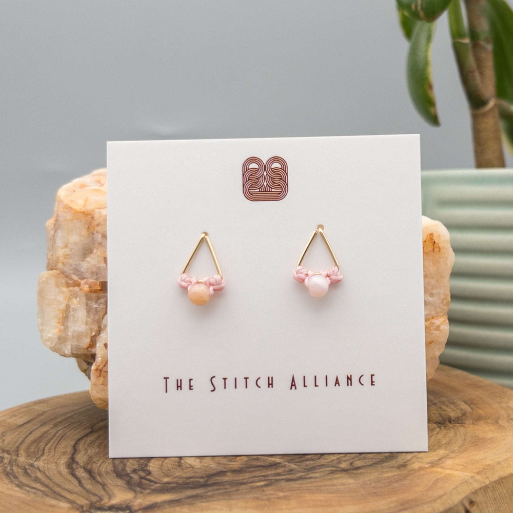 14k gold filled triangle shaped post-style earrings with a 4mm pink opal bead on a white background